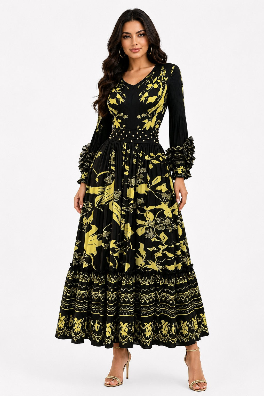 Model wearing the Printed Tiered Pleated Maxi Dress in Black and Gold featuring a bold abstract print, cascading pleated tiers, long sleeves, and an elegant maxi silhouette by For Her NYC
