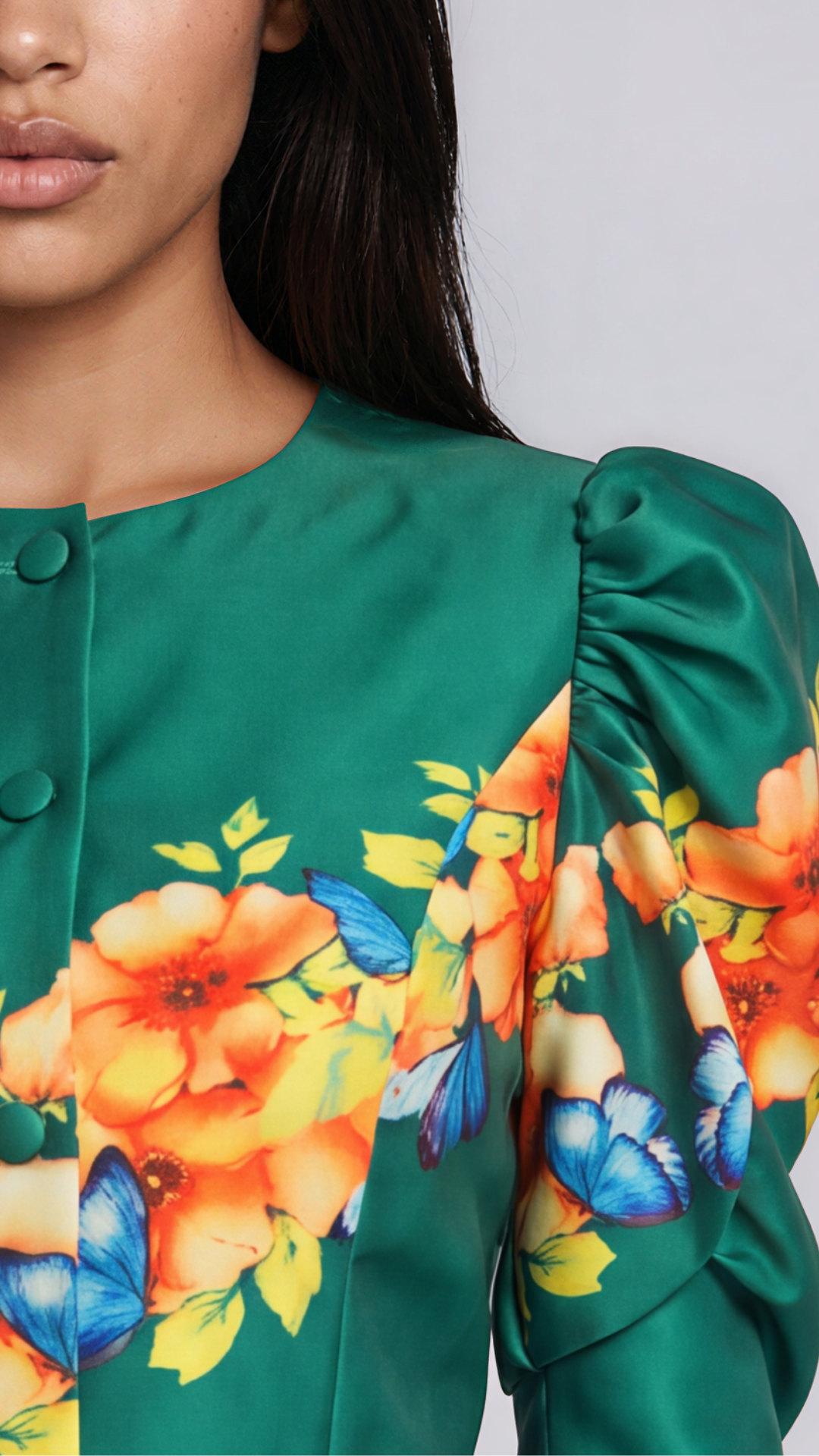 Close-up view of model wearing the emerald green Tally Taylor Floral Puff Sleeve Jacket & Midi Skirt Set – T5749, showing covered buttons and orange, yellow, and blue floral details