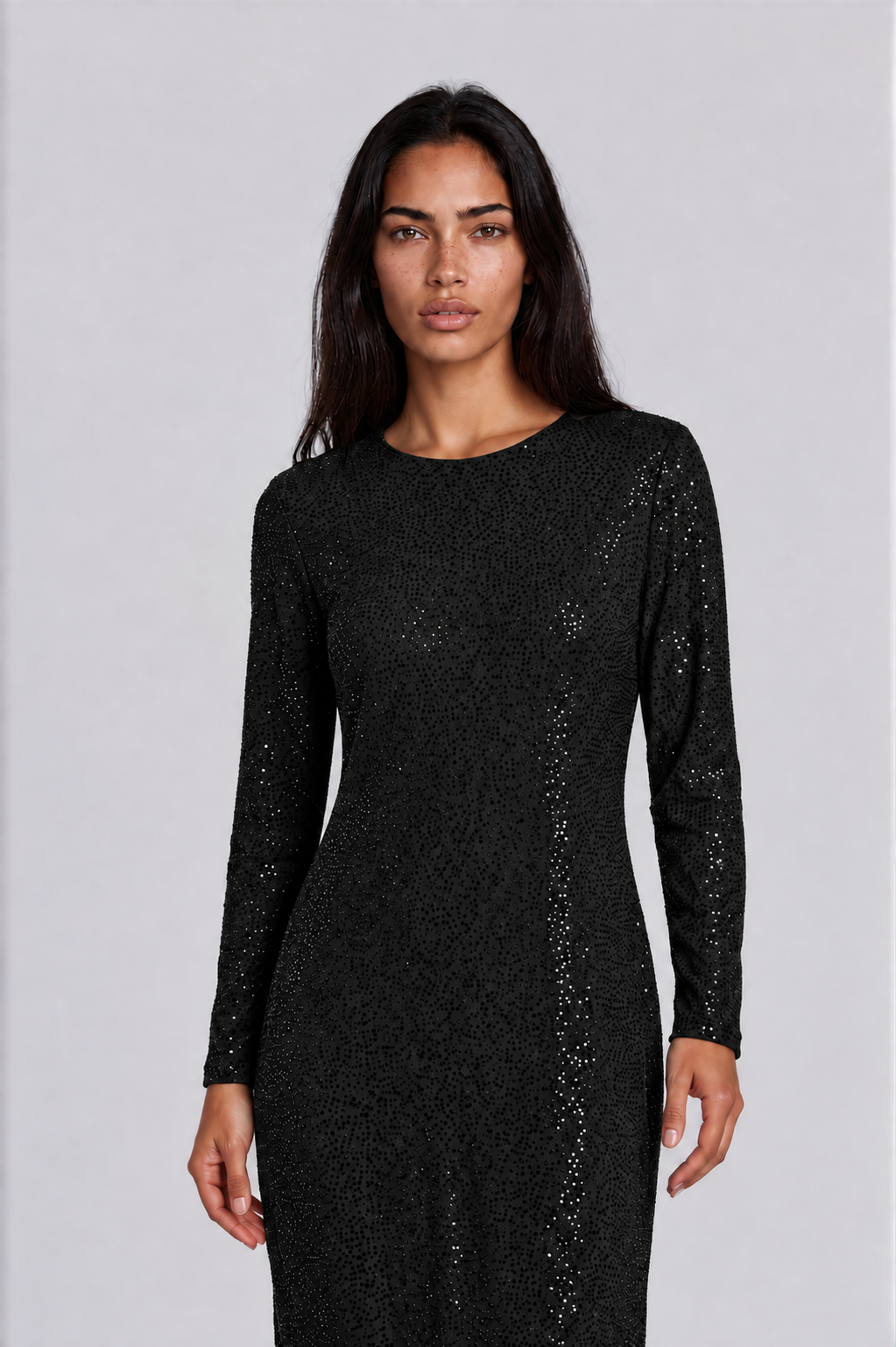 Close-up of a model wearing the black Tally Taylor Glimmer Sheath Dress - 5388, highlighting the round neckline, long sleeves, and sparkling surface details