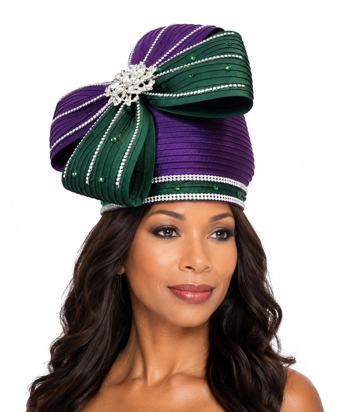 Model wearing the Tally Taylor Jeweled Bow Church Hat in purple and green, featuring crystal embellishments and an oversized statement bow, style H0617.