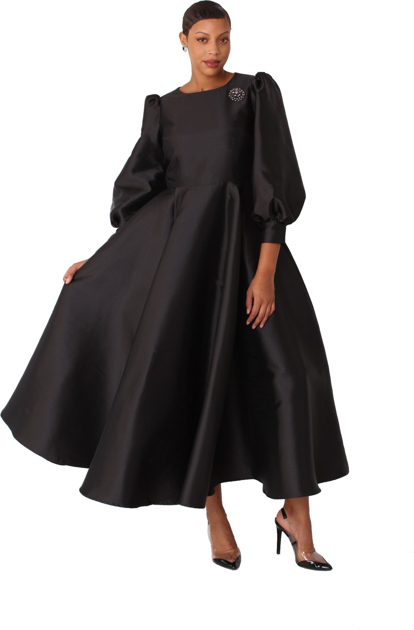 Black elegant long dress with bishop sleeves and brooch detail walking pose Tally Taylor