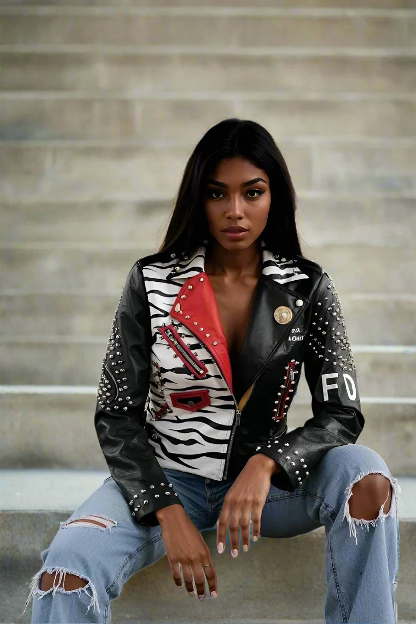 Zebra printed faux leather moto jacket styled seated highlighting bold print and relaxed moto fit, alternate front pose, For Her NYC