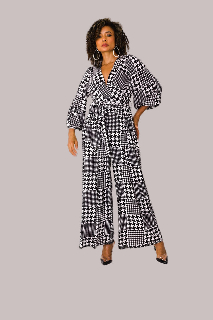 Model wearing houndstooth wide-leg jumpsuit with puff sleeves standing front-facing by For Her NYC