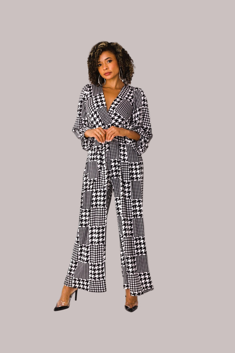 Model wearing houndstooth wide-leg jumpsuit with puff sleeves standing front-facing by For Her NYC