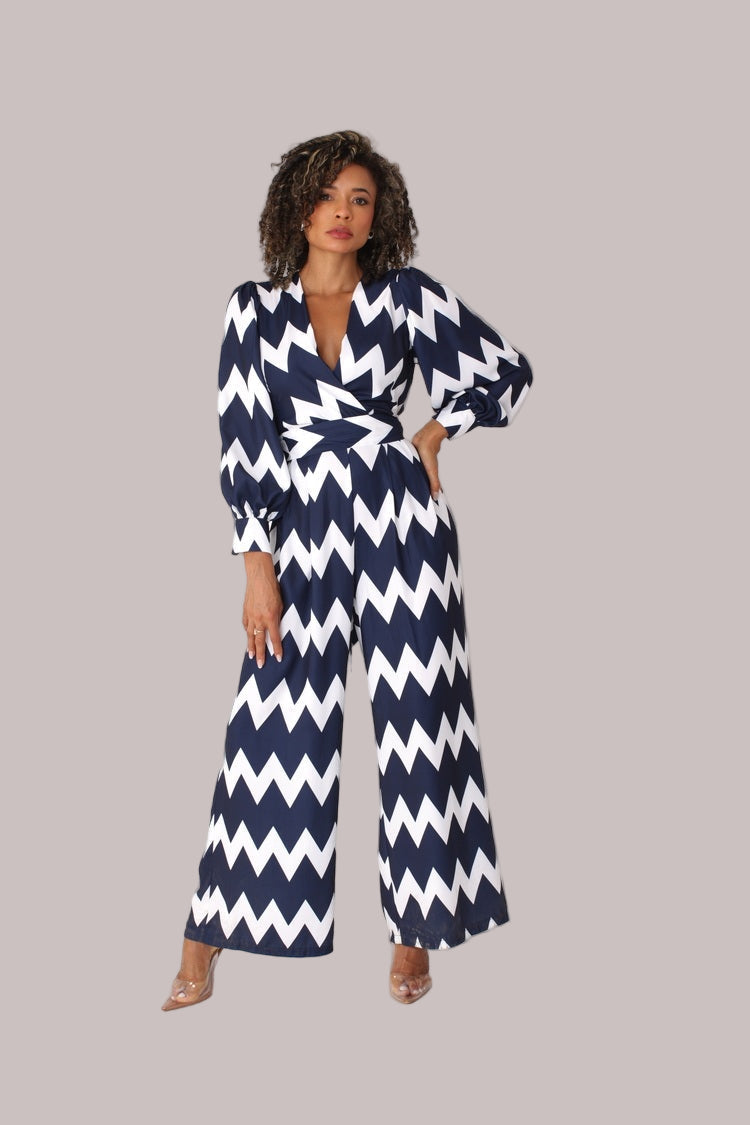 Model walking in navy and white chevron wide-leg jumpsuit with puff sleeves in motion by For Her NYC