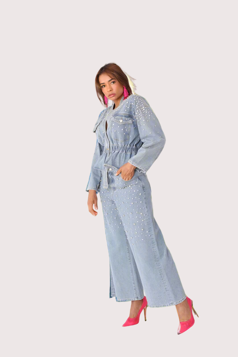 Pearl Cascade peplum denim jacket style 82325 in denim shown in a side standing pose highlighting the peplum shape, pearl detailing, and structured denim fit by For Her NYC