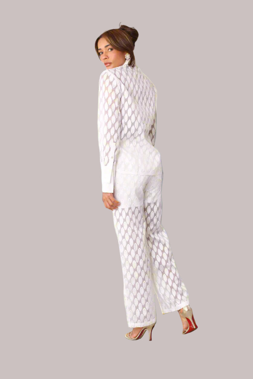 Eyelet wide-leg pants style 82339 in white shown from the side in a standing pose emphasizing the airy eyelet texture and flowing wide-leg cut by For Her NYC