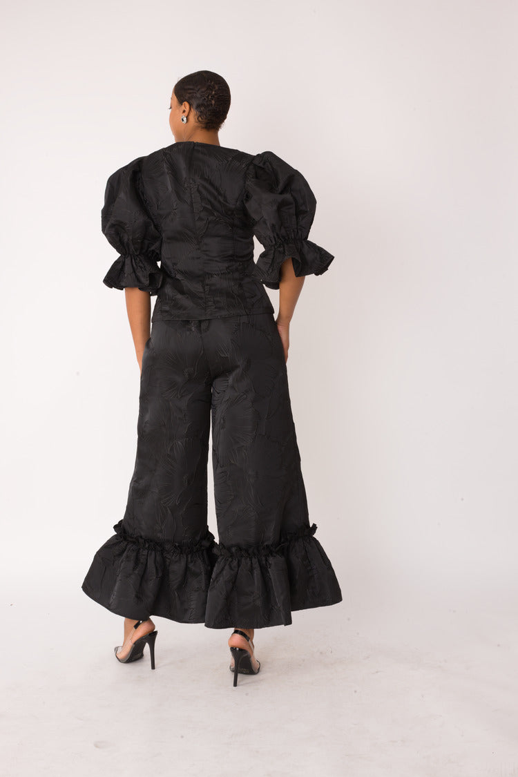 Midnight Drama ruffle set style 82375 in black shown from the back in a standing pose showcasing the full skirt volume and elegant drape by For Her NYC
