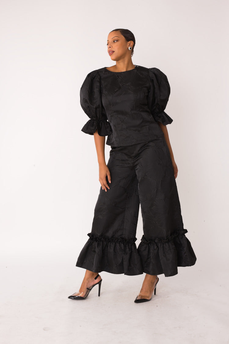 Midnight Drama ruffle set style 82375 in black shown at a slight side angle in a standing pose highlighting the sculpted sleeves and structured fit by For Her NYC