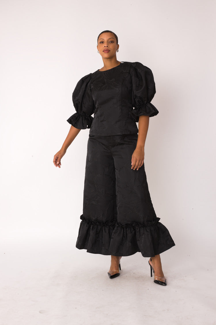 Midnight Drama ruffle set style 82375 in black shown in a forward walking pose emphasizing the dramatic silhouette and flowing ruffle details by For Her NYC