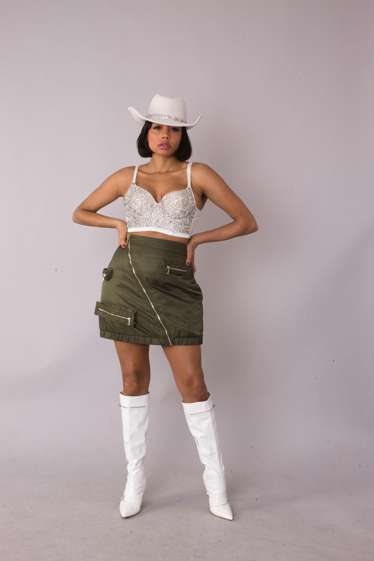 Model posing in olive utility cargo mini skirt with hands on hips, front view, For Her NYC