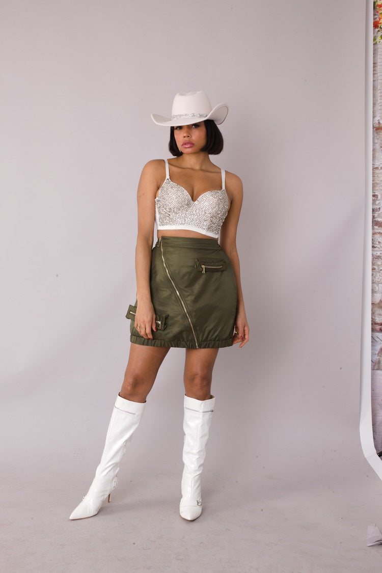 Model wearing olive utility cargo mini skirt, slight angle fashion pose, For Her NYC