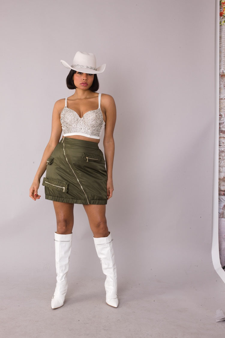 Model wearing olive utility cargo mini skirt, slight angle fashion pose, For Her NYC