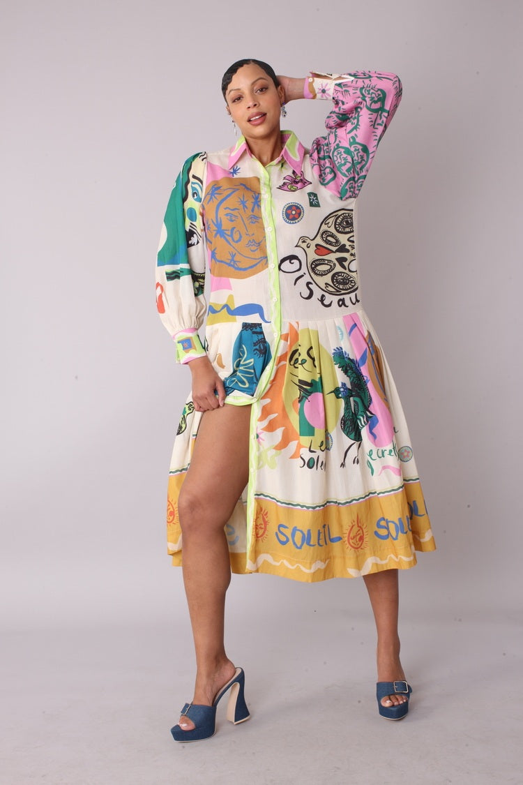 Model holding skirt of artistic print shirt dress to show movement and print detail, For Her NYC