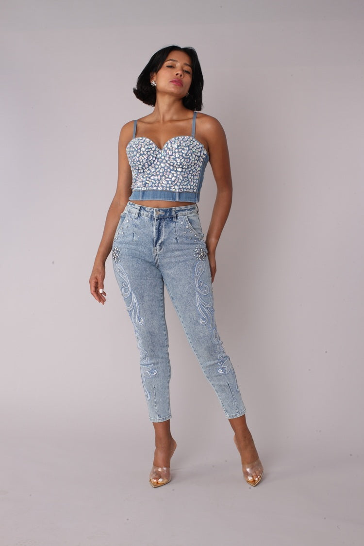 Model posing in embroidered capri denim jeans with side leg embroidery detail, angled view, For Her NYC