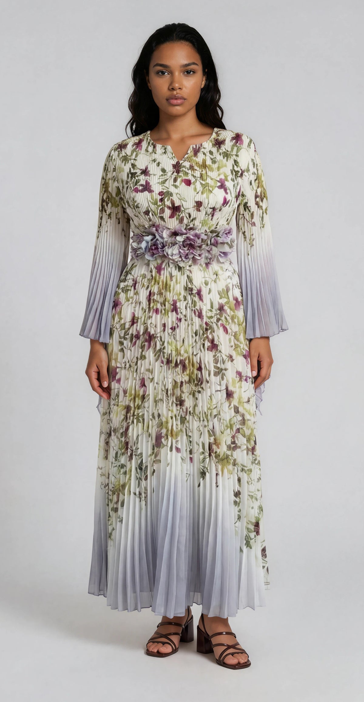 Silver multi floral pleated maxi dress with flowing pleats and sheer sleeves modeled in a clean studio setting For Her NYC Silver Multi