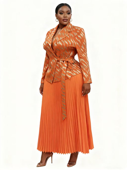 83009 orange Multi Woman wearing a flowing orange pleated midi skirt with a coordinating patterned wrap-style jacket and tie waist, styled with heels — For Her NYC