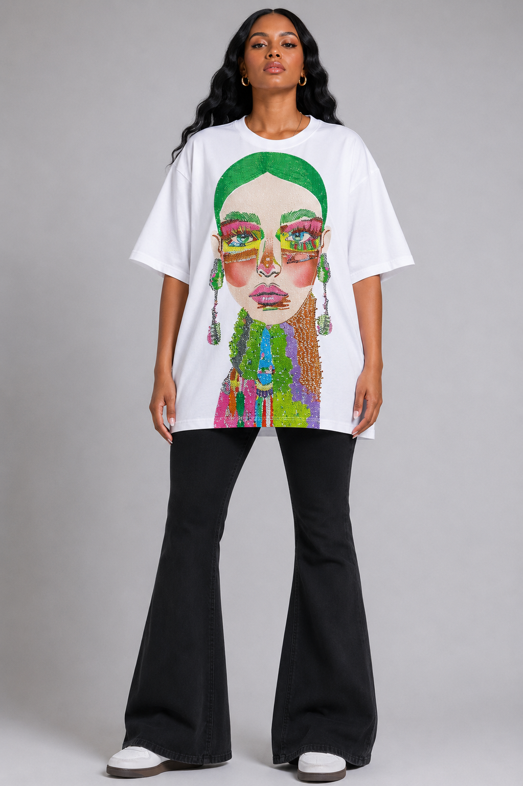 White/Multi graphic tee featuring vibrant electric portrait artwork with rhinestone detailing, model standing front view wearing tall boots For Her NYC