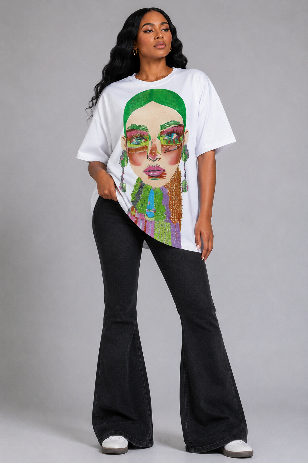 White/Multi graphic tee featuring vibrant electric portrait artwork with rhinestone detailing, model standing front view wearing tall boots For Her NYC