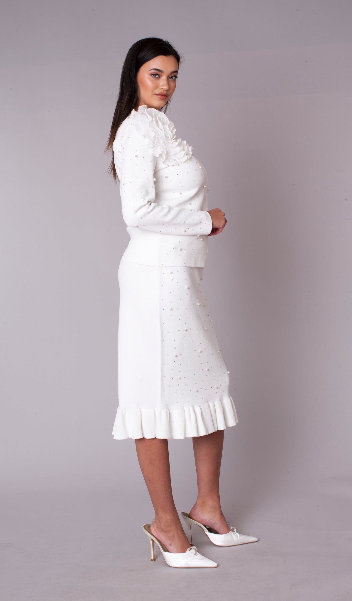 Side view of a white two-piece skirt suit featuring 3D floral appliqué shoulder and elegant fitted silhouette — Tally Taylor