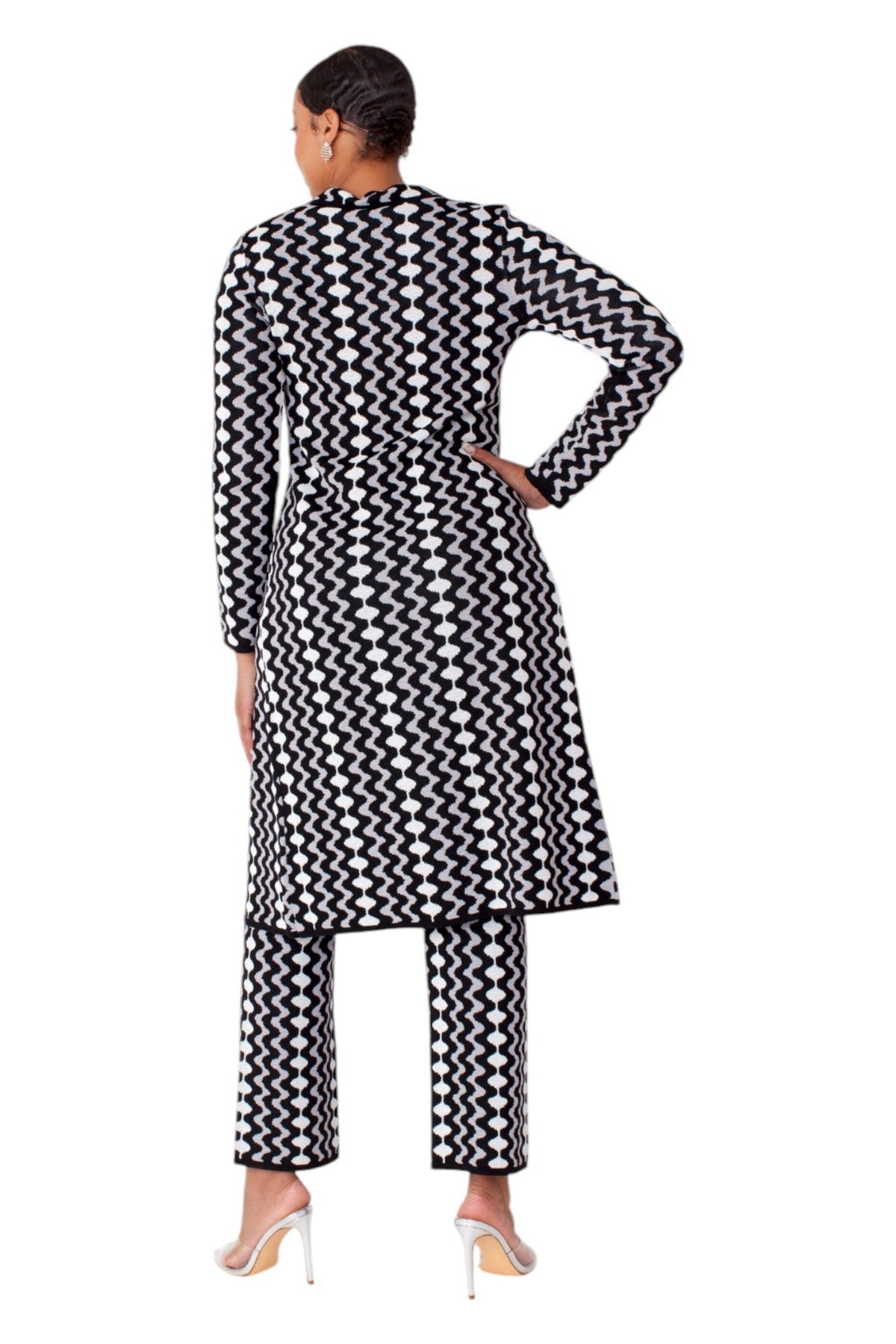 Model wearing black and white chevron knit duster coat and pant set, back standing pose by Tally Taylor