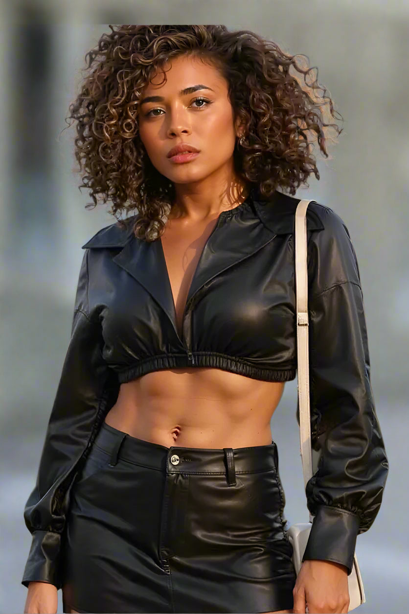 Front view of black cropped faux leather wrap top with long sleeves for a bold fashion forward streetwear look.