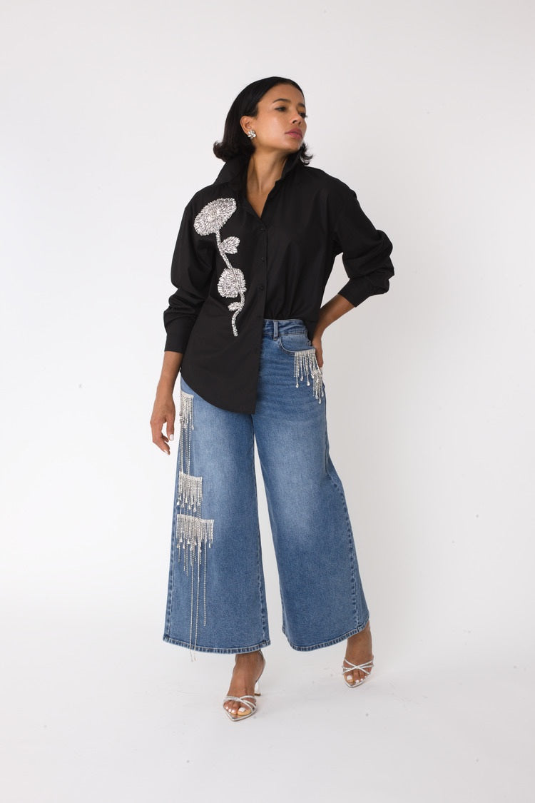 Model wearing the denim crystal cascade wide leg jeans walking forward, highlighting dramatic wide leg shape and flowing crystal detail by For Her NYC