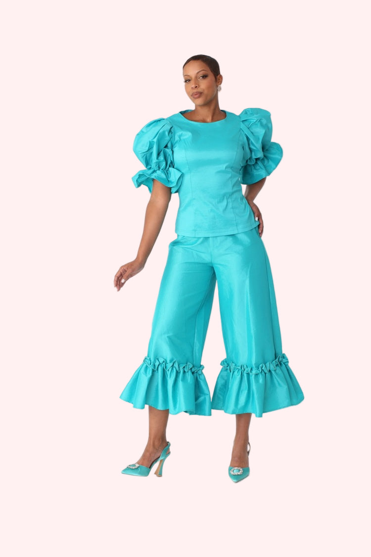 Model posing with arm raised wearing jade dramatic ruffle hem wide leg pants emphasizing statement hem by For Her NYC