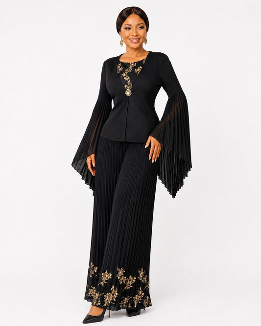 Front view of a model wearing the black For Her NYC Embellished Pleated Pant Set - 83469 with gold floral details, a fitted jacket-style top, dramatic pleated bell sleeves, and wide-leg pleated pants