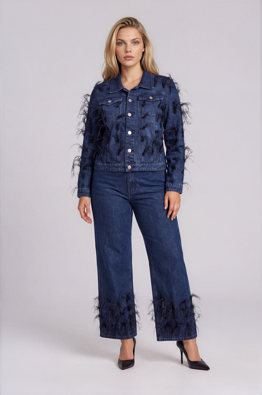 Front view of a model wearing the dark-wash For Her NYC Feather Trim Denim Jacket - 82303 with long sleeves, chest pockets, metal buttons, and wispy feather details