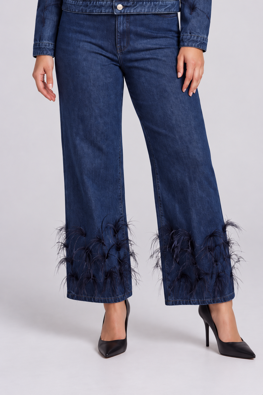 detail view of a model wearing the dark-wash For Her NYC Feather Trim Wide Leg Jeans - 82304, highlighting the wide legs and feather-embellished hems