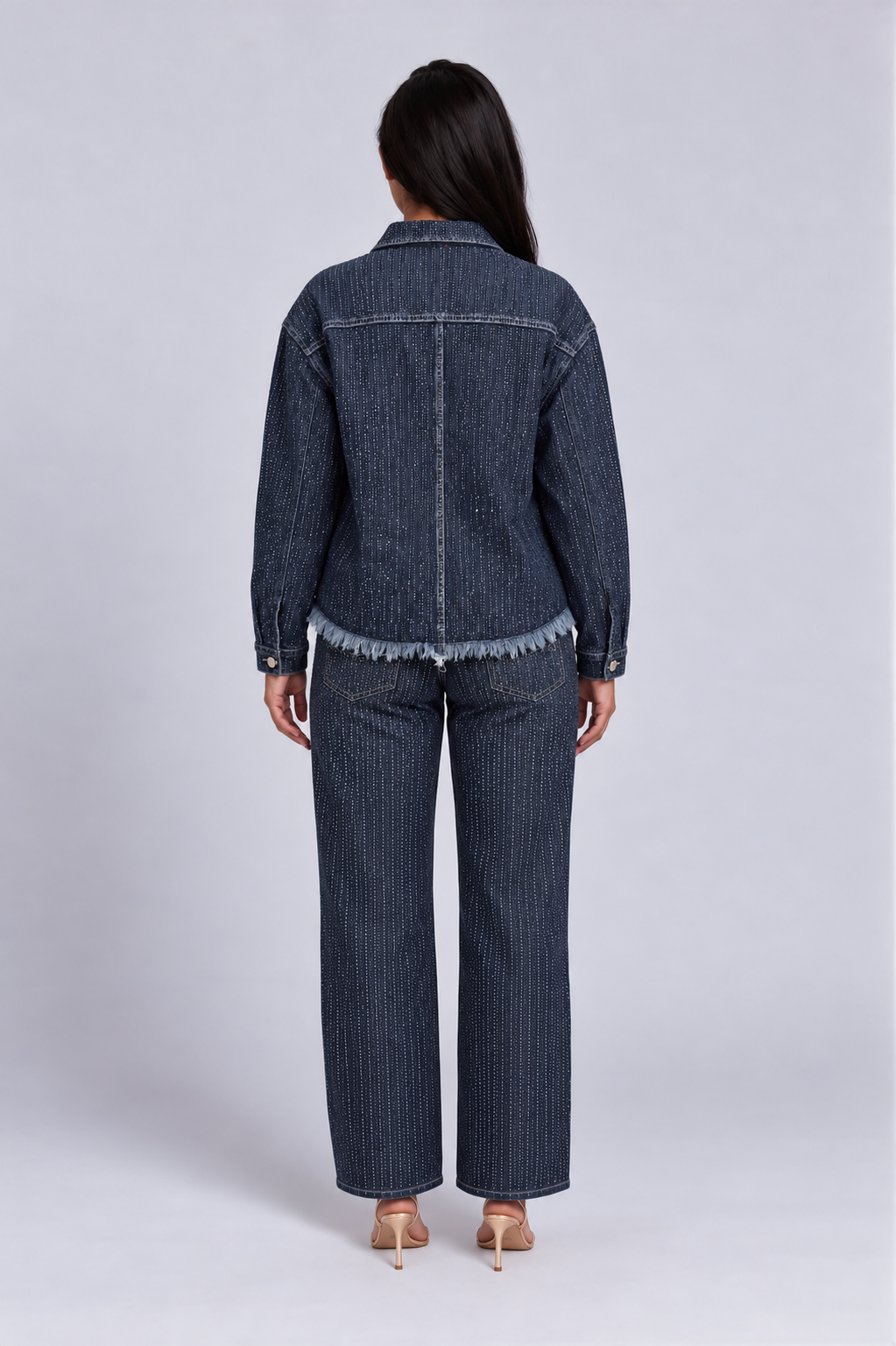 Back view of a model wearing the For Her NYC Glitter-Effect Flared Denim Pants - 82955 with an allover vertical glitter pattern