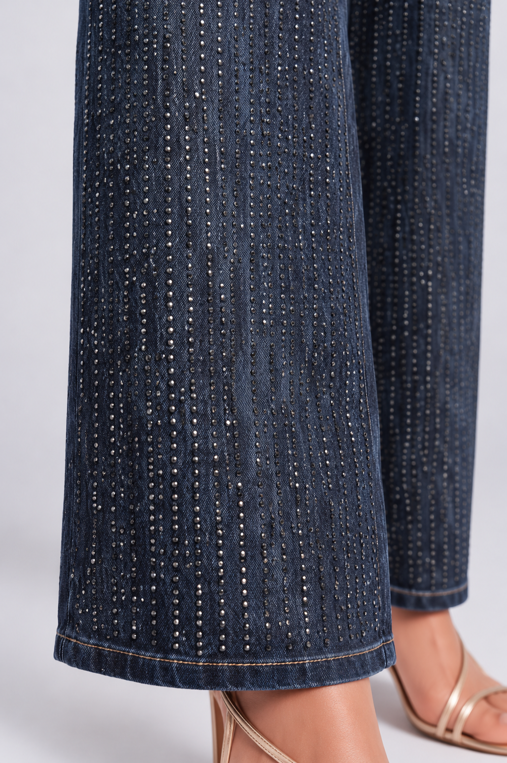 Close-up of a model wearing the For Her NYC Glitter-Effect Flared Denim Pants - 82955, highlighting the dense vertical glitter pattern and denim hem