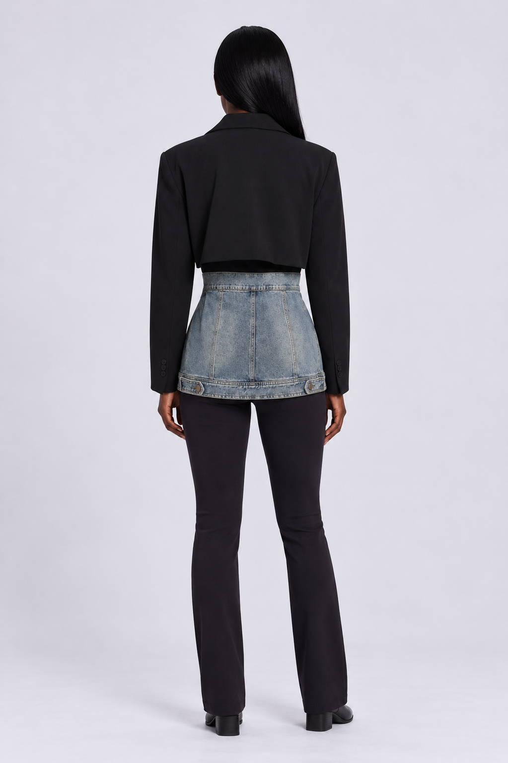 Back view of a model wearing the For Her NYC Hybrid Blazer Denim Jacket - 82429 with contrasting black blazer and washed denim panels