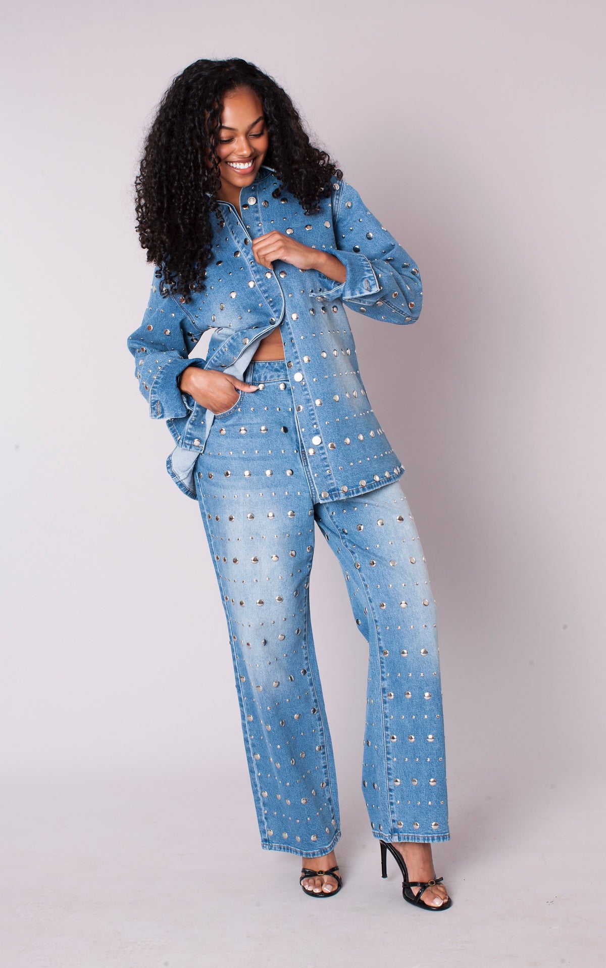 Front view of a model wearing the light-wash For Her NYC Mirror Stud Wide-Leg Denim Jeans - 83037 with mixed-size silver stud embellishments