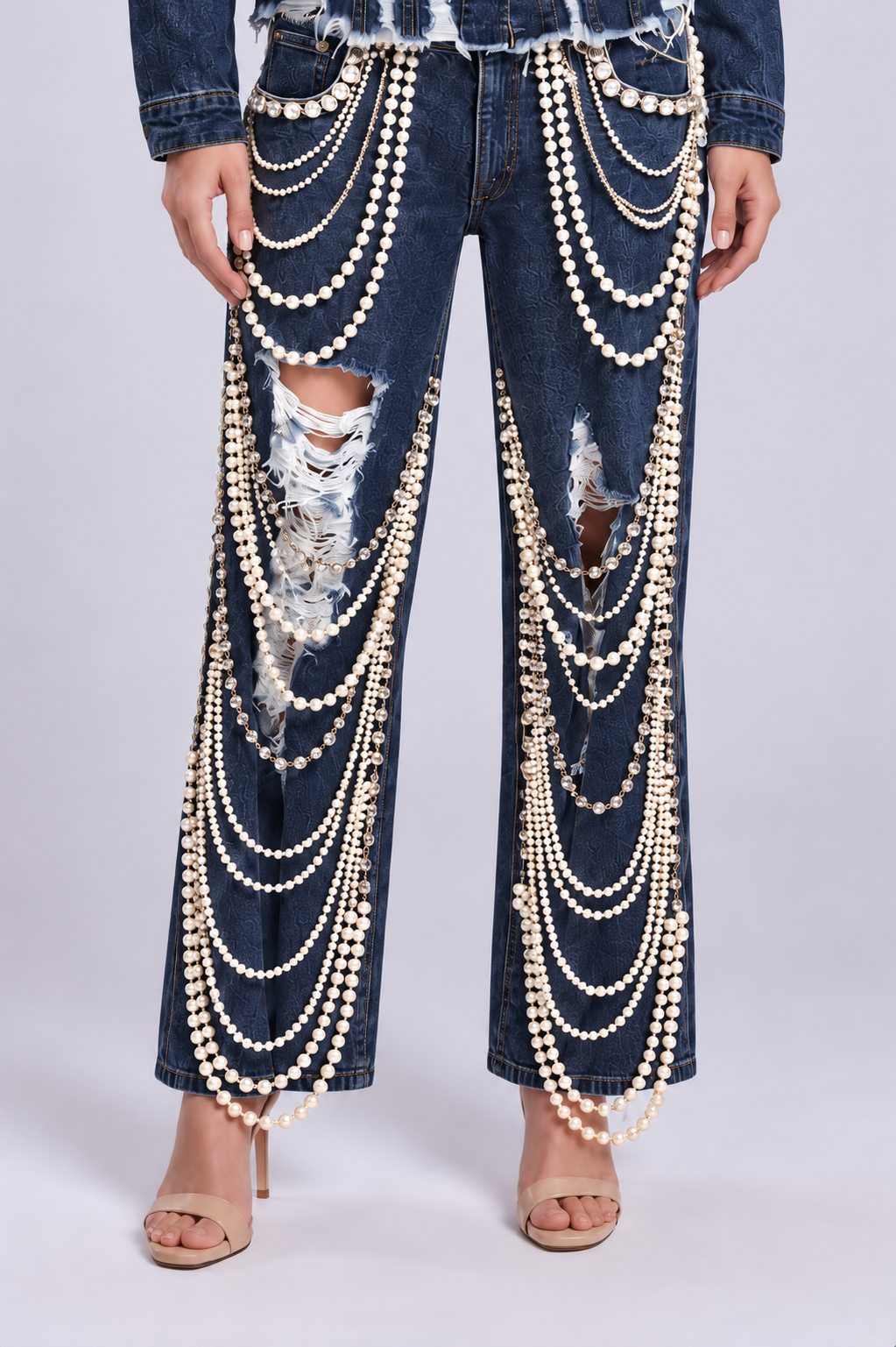 Front detail of a model wearing the dark-wash For Her NYC Pearl Wide-Leg Denim Pants - 82776 with distressed knees and layered pearl embellishments