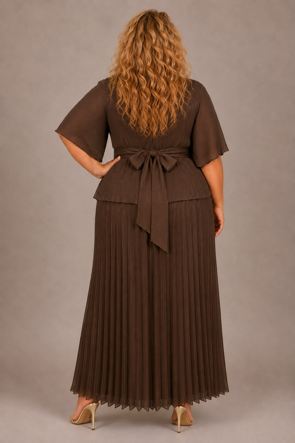 Back view of a plus-size model wearing the brown For Her NYC Plus Size Embellished Pleated Midi Dress - S0269W with short sleeves, a pleated skirt, and a tie waist