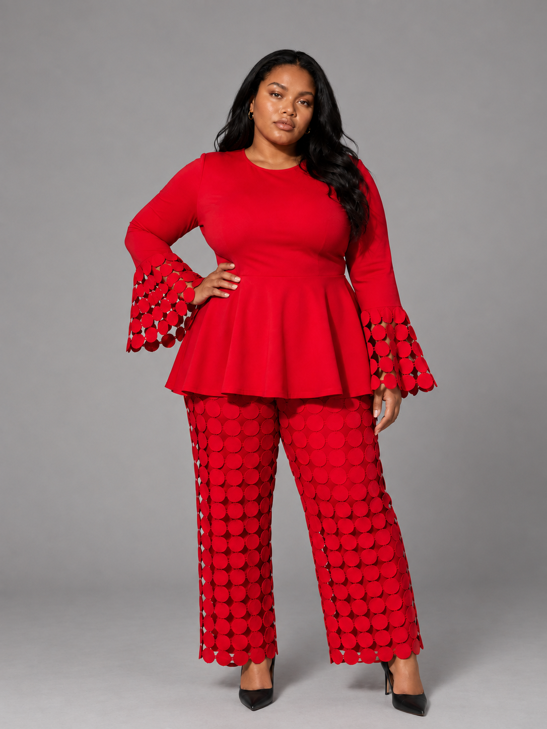 Front view of a plus-size model wearing the red For Her NYC Plus Size New Dimension Peplum Pant Set - U0561W with circular cutout detailing, flared cuffs, and wide-leg pants