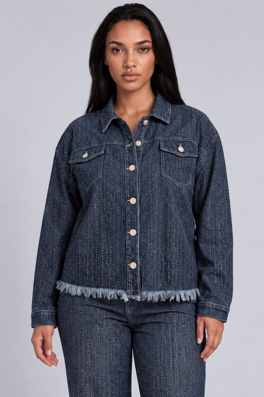 Close front view of a model wearing the For Her NYC Rhinestone Embellished Denim Jacket - 82978 with vertical rhinestone rows, chest pockets, and a frayed hem