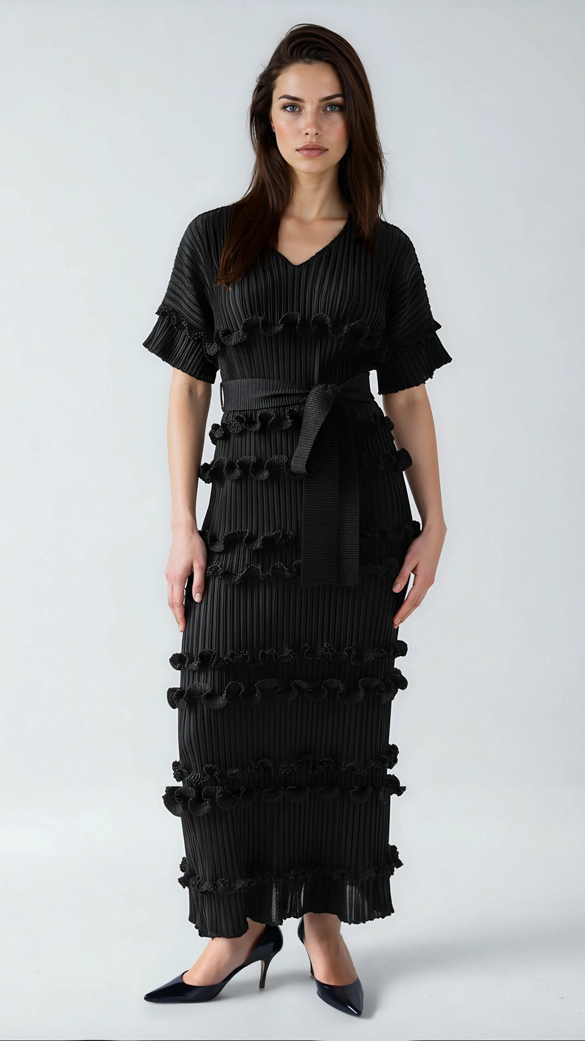 Model wearing black ruffled pleated maxi dress with waist tie and tiered texture by For Her NYC.