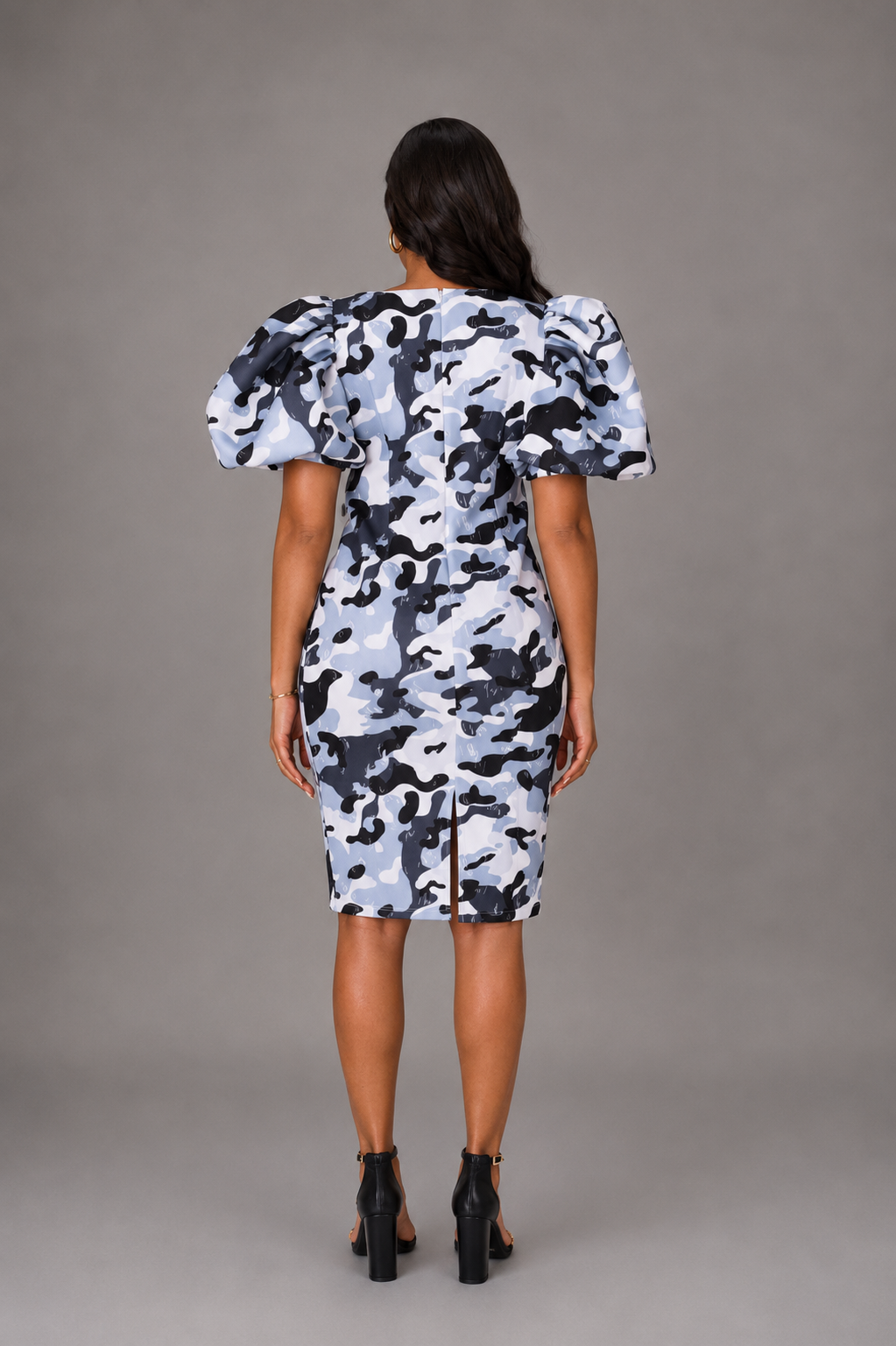 Model wearing grey camouflage scuba midi dress with puff sleeves and classic silhouette.