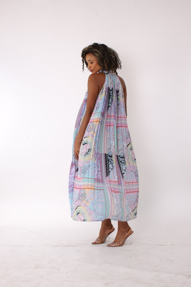Side profile view of pastel patchwork halter maxi dress highlighting flowy pleated skirt and halter neckline – For Her NYC