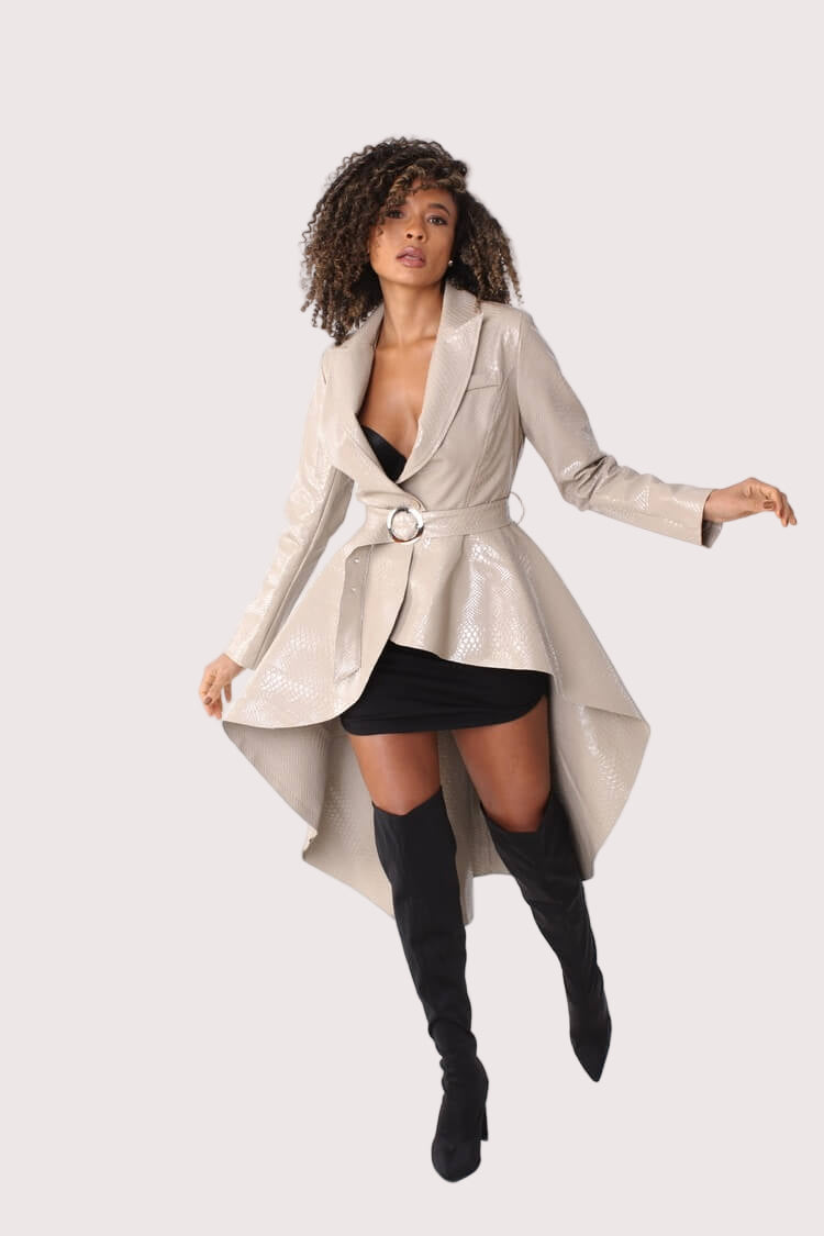 Nude high-low belted coat turning pose showing asymmetrical hem – For Her NYC