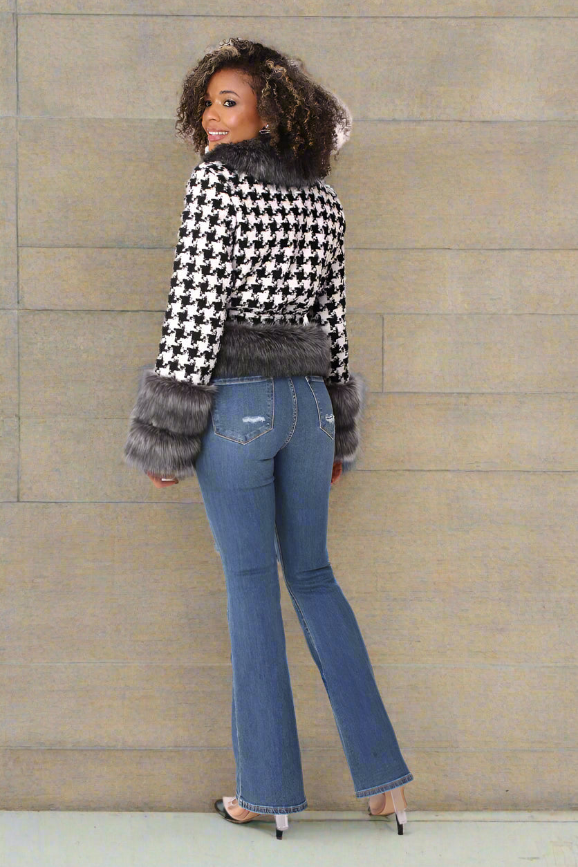 Back view of a black and white houndstooth belted jacket, showcasing the structured back, belt placement, and faux fur trim details by For Her NYC