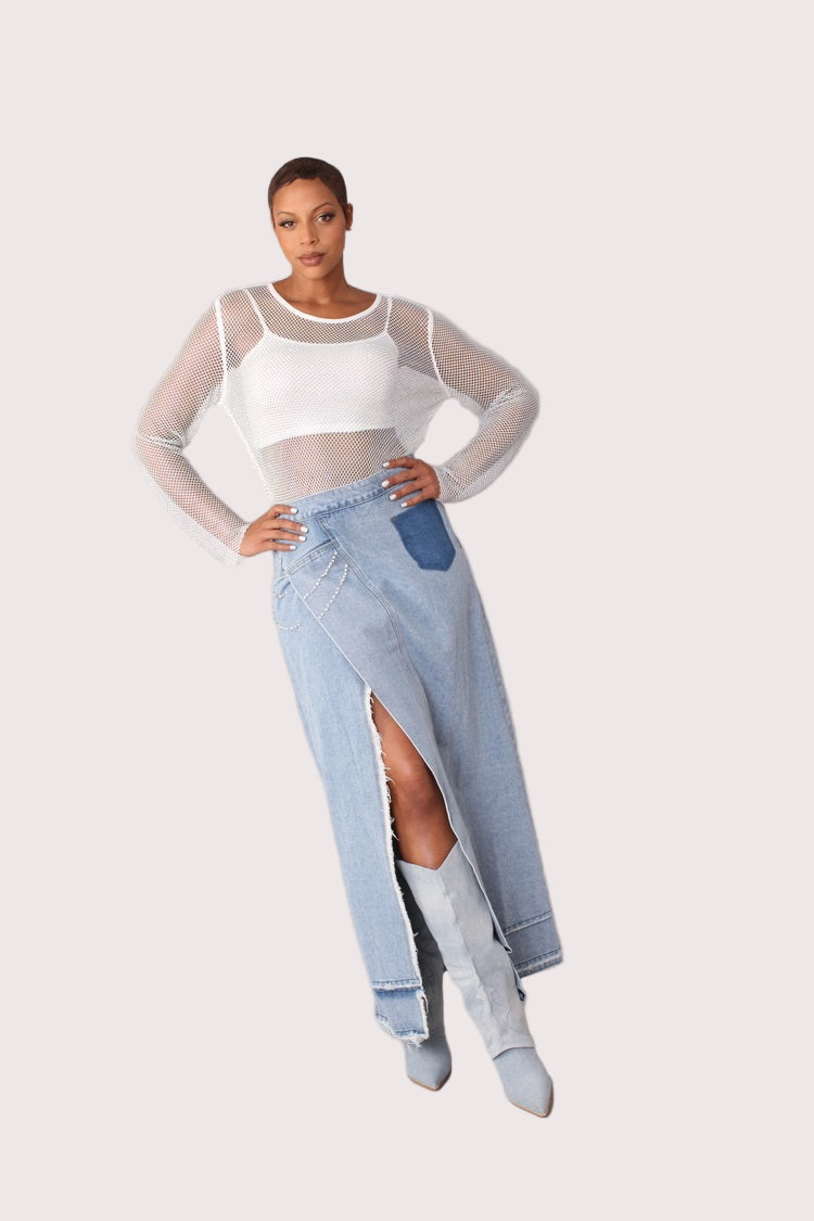 Front view of light wash long denim skirt with side slit shown with hand on hip pose emphasizing waist fit and sparkling details, For Her NYC