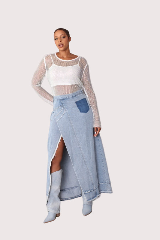 Front view of light wash long denim skirt with dramatic side slit and crystal embellishments, styled standing to highlight silhouette and slit detail, For Her NYC