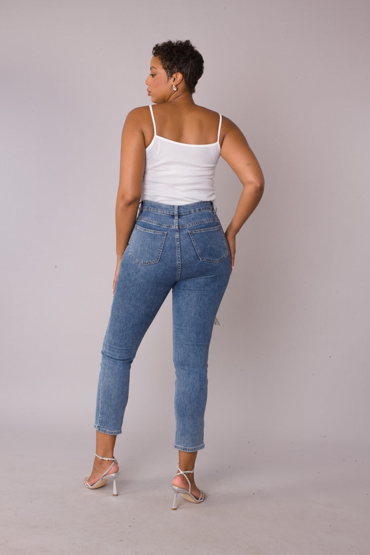 Back view of model wearing the denim metallic fringe cropped jeans showing slim fit silhouette and fringe placement throughout by For Her NYC