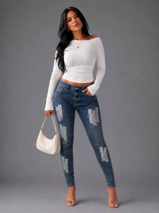 Front view of model wearing the denim metallic fringe cropped jeans highlighting ankle length cut and embellished chain fringe accents by For Her NYC