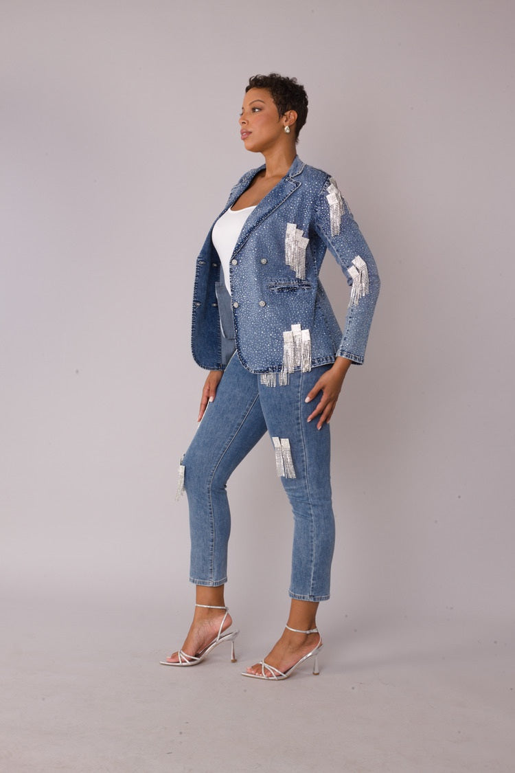 Model wearing the denim metallic fringe cropped bomber jacket and matching cropped jeans in a three quarter side profile, highlighting silver chain fringe detailing and coordinated denim set by For Her NYC