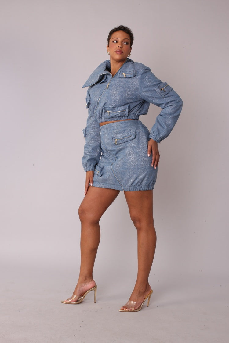 Three quarter angled view of model wearing the denim silver metallic shimmer mini skirt highlighting structured fit and subtle shine by For Her NYC